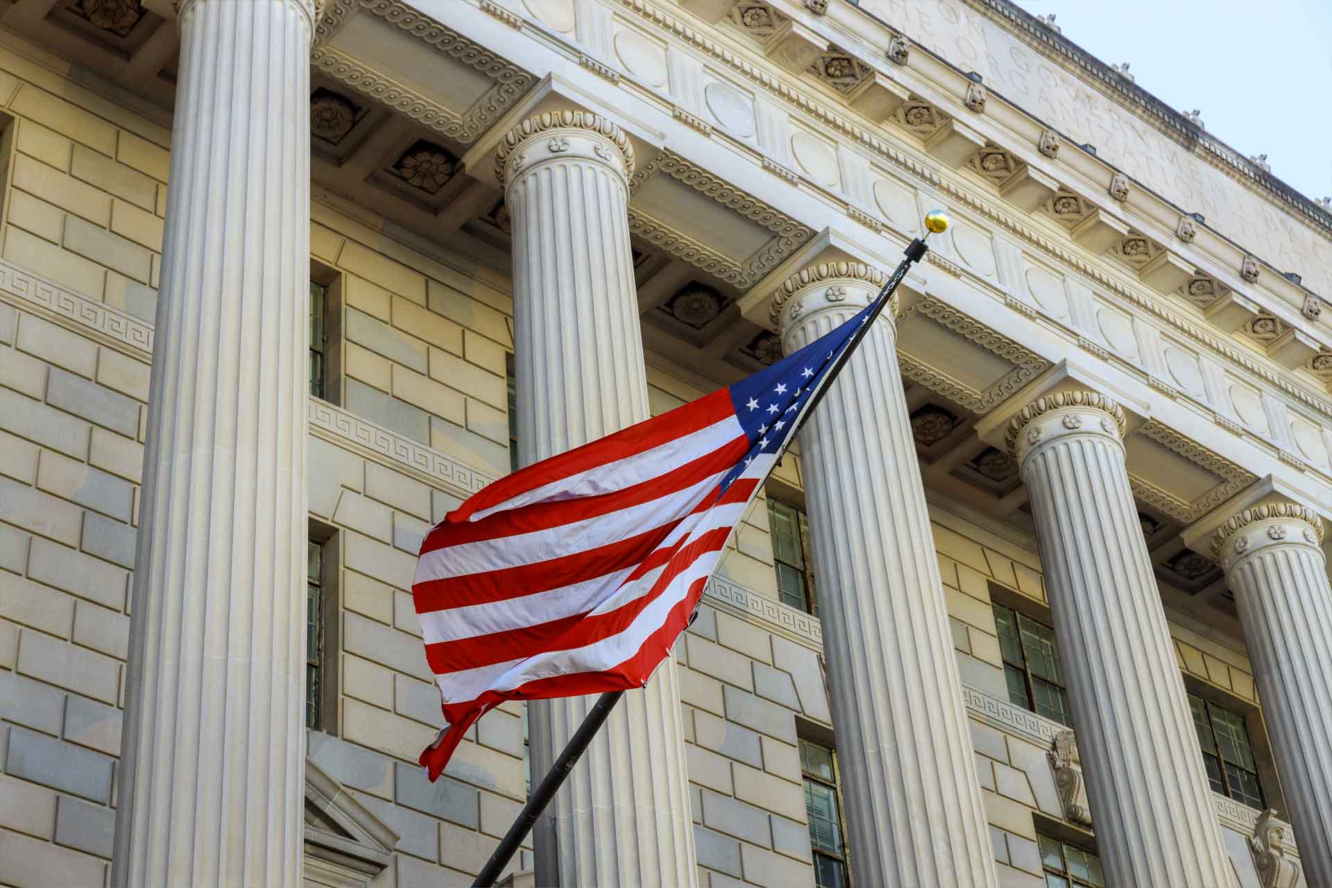 Government Financial american flag front of federal building columns